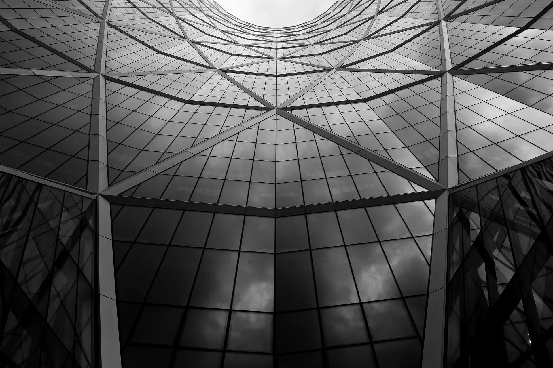 Blick nach oben an einer hellen Hausfassade mit großen Fenstern
